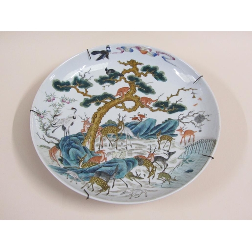 139 - A pair of 19c Chinese famille verte chargers decorated with deer under a pine tree with monkeys and ... 