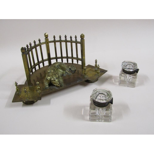 20 - An early 20c gilt metal two bottle inkstand formed as a lying dog backed by a curved fence and havin... 