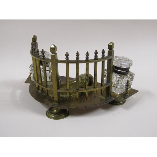 20 - An early 20c gilt metal two bottle inkstand formed as a lying dog backed by a curved fence and havin... 