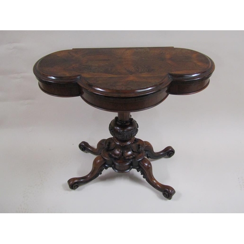 276 - A Victorian rosewood fold over card table of quatrefoil form, supported on a carved baluster column ... 