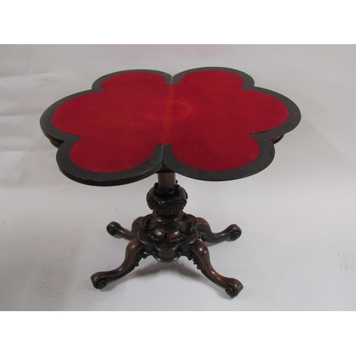 276 - A Victorian rosewood fold over card table of quatrefoil form, supported on a carved baluster column ... 