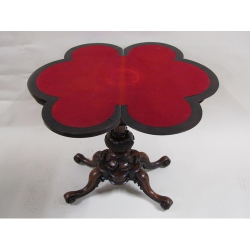 276 - A Victorian rosewood fold over card table of quatrefoil form, supported on a carved baluster column ... 