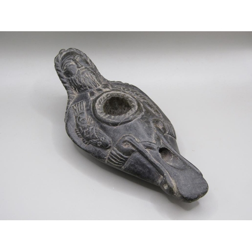 42 - A Syrian carved black stone oil lamp, carved with a bearded man with long plats and fishes, 13.5cm l... 