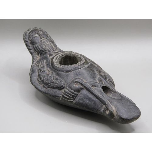 42 - A Syrian carved black stone oil lamp, carved with a bearded man with long plats and fishes, 13.5cm l... 