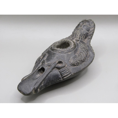 42 - A Syrian carved black stone oil lamp, carved with a bearded man with long plats and fishes, 13.5cm l... 