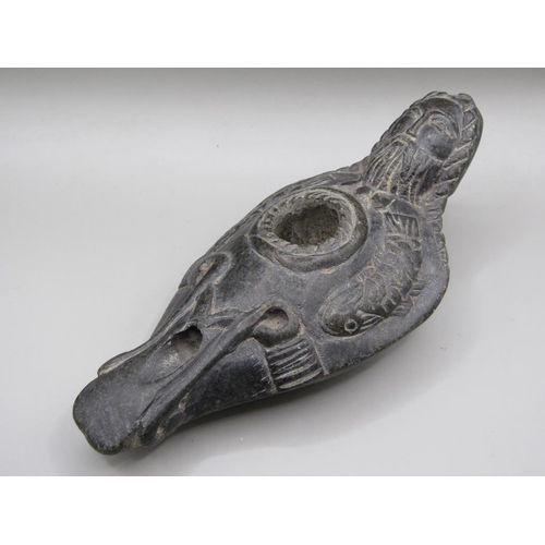 42 - A Syrian carved black stone oil lamp, carved with a bearded man with long plats and fishes, 13.5cm l... 