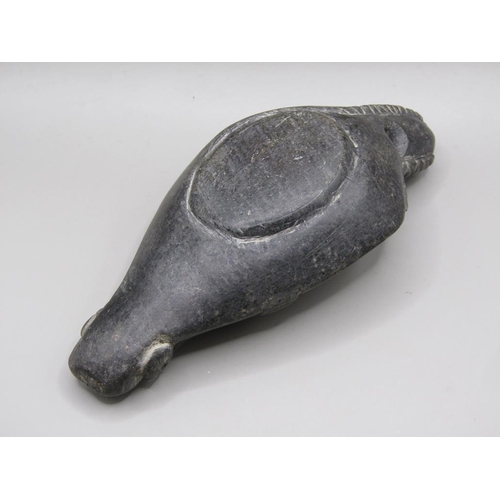 42 - A Syrian carved black stone oil lamp, carved with a bearded man with long plats and fishes, 13.5cm l... 