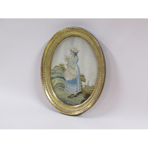 162 - An early 19c silk work picture of a lady gathering corn, oval framed and glazed, 17cm x 24cm.