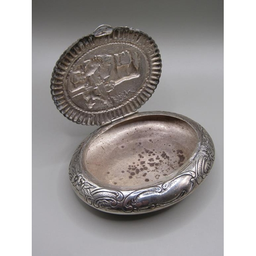 78 - An Edwardian Dutch tobacco box of oval form embossed and chased, the lid with a panel of cattle unde... 