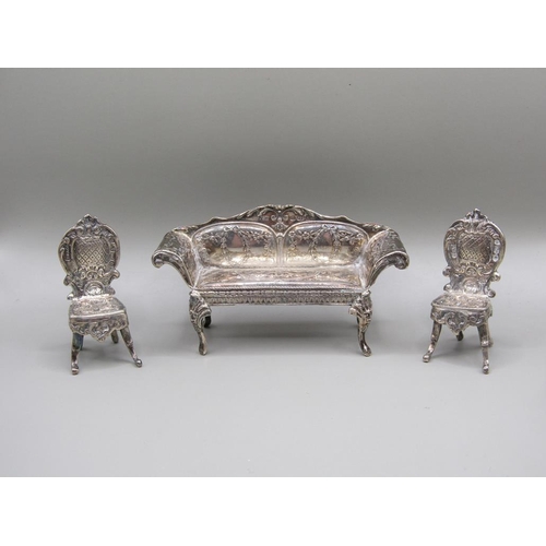 79 - An early 20c Continental silver miniature two seater sofa with scrolling arms and cabriole legs and ... 