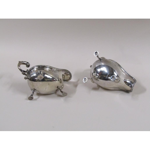 101 - A pair of Mappin & Webb Georgian style sauce boats with open double scroll handles, cast gadroon rim... 