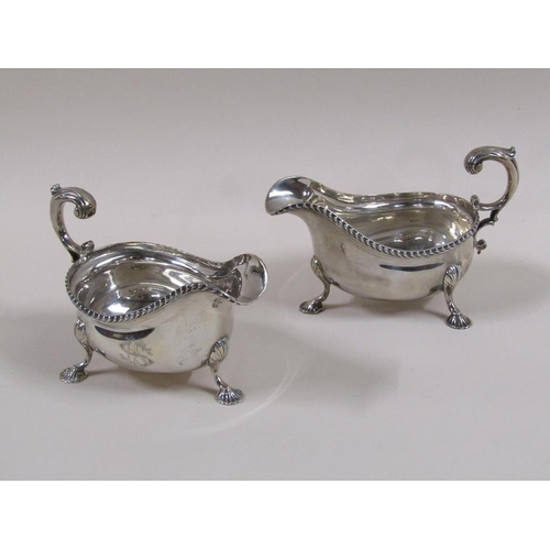 101 - A pair of Mappin & Webb Georgian style sauce boats with open double scroll handles, cast gadroon rim... 