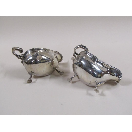 101 - A pair of Mappin & Webb Georgian style sauce boats with open double scroll handles, cast gadroon rim... 