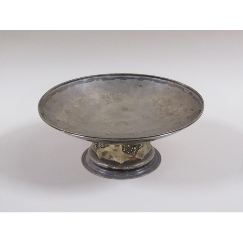 102 - A silver fruit bowl of circular dish form, on a facet base with fruiting vine embossing and circular... 