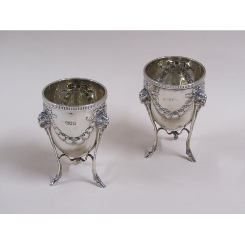 105 - A pair of silver cups on stands, the cups of ovoid form cast with garland and bow, the legs having r... 