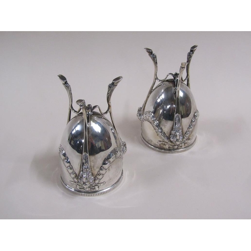 105 - A pair of silver cups on stands, the cups of ovoid form cast with garland and bow, the legs having r... 