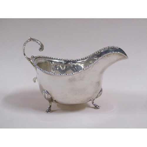 106 - A pair of Georgian style silver gravy boats with open scroll handles, bead and reel cast borders, ea... 