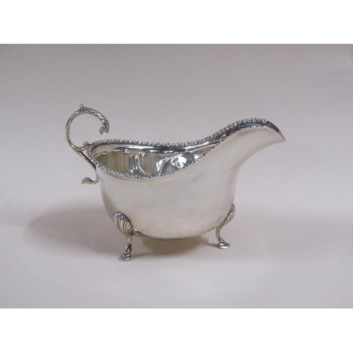 106 - A pair of Georgian style silver gravy boats with open scroll handles, bead and reel cast borders, ea... 