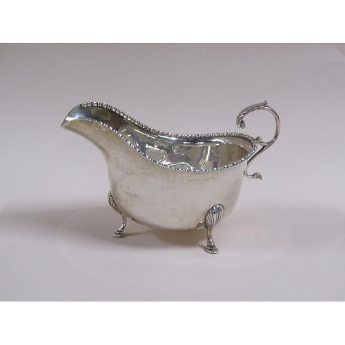 106 - A pair of Georgian style silver gravy boats with open scroll handles, bead and reel cast borders, ea... 