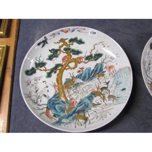 139 - A pair of 19c Chinese famille verte chargers decorated with deer under a pine tree with monkeys and ... 