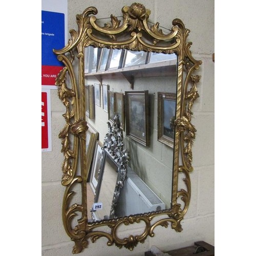 292 - An 18c style gilt wood wall mirror, the frame scroll and leaf carved with rose mounts, 89cm x 53cm.