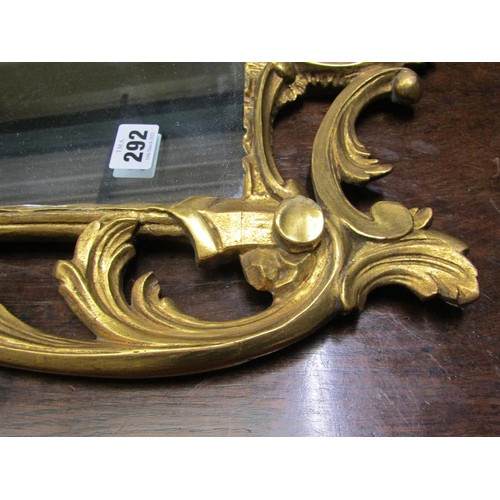 292 - An 18c style gilt wood wall mirror, the frame scroll and leaf carved with rose mounts, 89cm x 53cm.