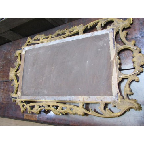 292 - An 18c style gilt wood wall mirror, the frame scroll and leaf carved with rose mounts, 89cm x 53cm.