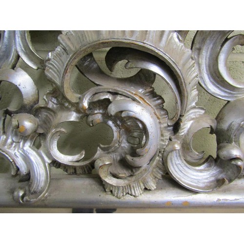 294 - A 19c style Florentine design silvered carved wood scrolling wall mirror,  137cm x 89cm overall.