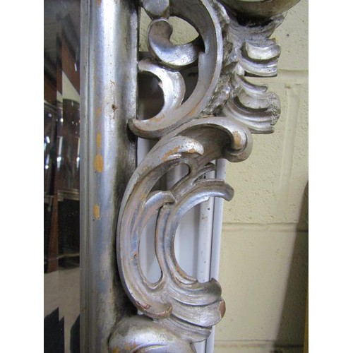 294 - A 19c style Florentine design silvered carved wood scrolling wall mirror,  137cm x 89cm overall.