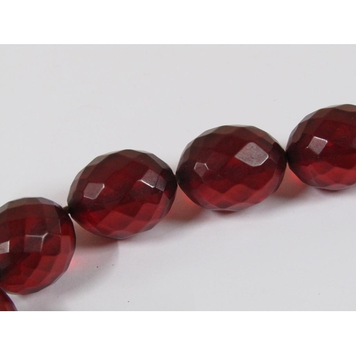 1327 - STRING OF CUT CHERRY AMBER TYPE BEADS, 52CM L