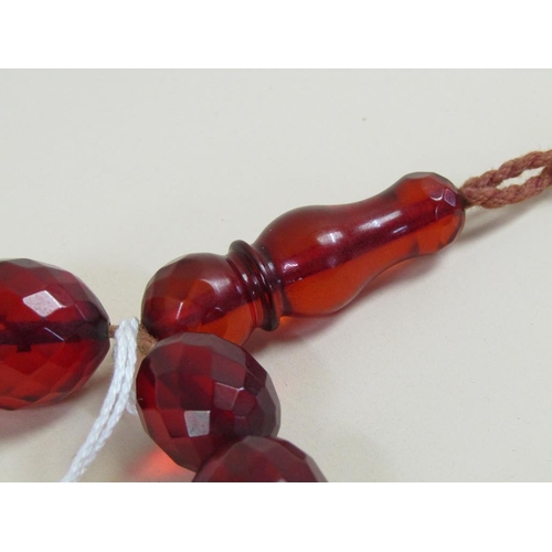 1485 - STRING OF CUT CHERRY AMBER TYPE BEADS