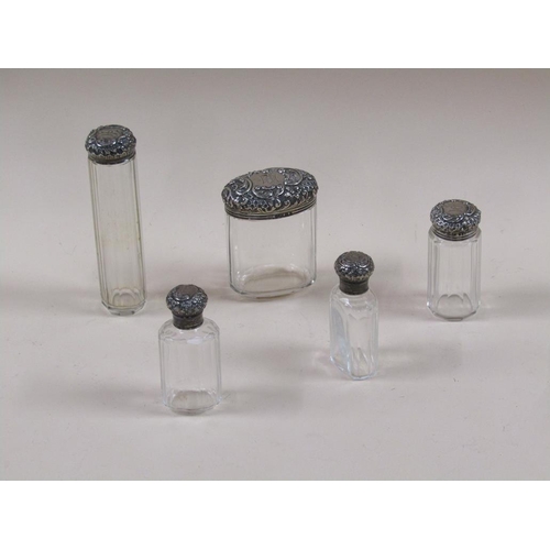 1693 - SIX CUT GLASS COSMETIC AND SCENT BOTTLES WITH SILVER COVERS