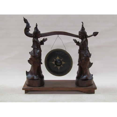 285 - A late 19c/early 20c Oriental hardwood dinner gong stand in the form of two Siamese figures supporti... 