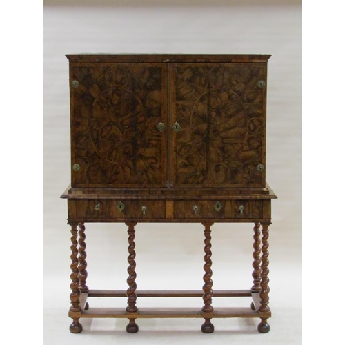 286 - An 18c oyster veneer cabinet on stand, the cabinet under a shallow moulded cornice enclosed by two h... 