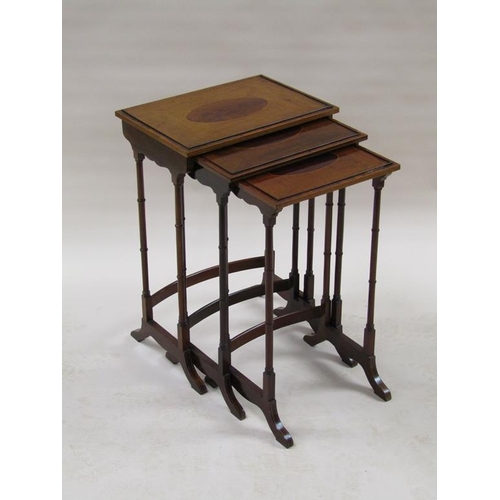 296 - A 19c nest of three figure mahogany occasional tables, the table tops with oval motifs, supported on... 