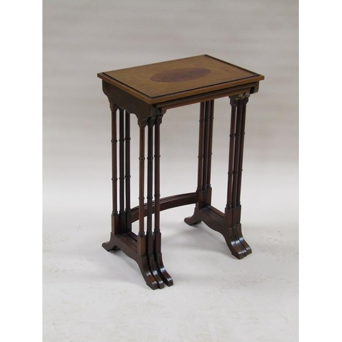 296 - A 19c nest of three figure mahogany occasional tables, the table tops with oval motifs, supported on... 