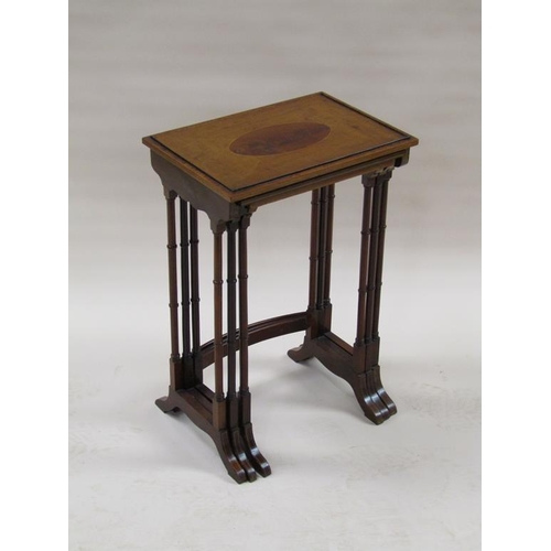 296 - A 19c nest of three figure mahogany occasional tables, the table tops with oval motifs, supported on... 