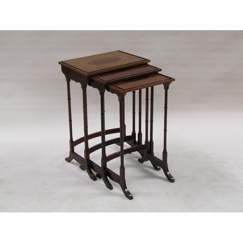 296 - A 19c nest of three figure mahogany occasional tables, the table tops with oval motifs, supported on... 