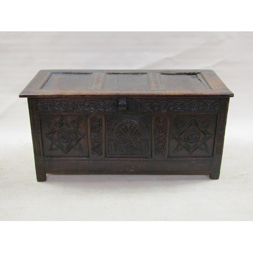 307 - A late 17c oak three panel coffer with a later hinged lid, the coffer panels carved with lunette and... 