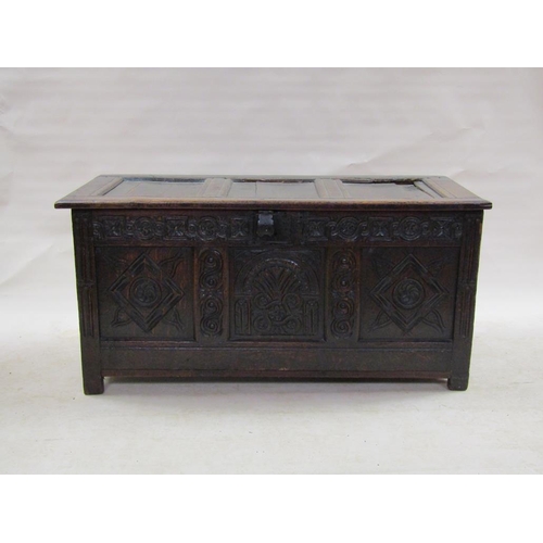 307 - A late 17c oak three panel coffer with a later hinged lid, the coffer panels carved with lunette and... 