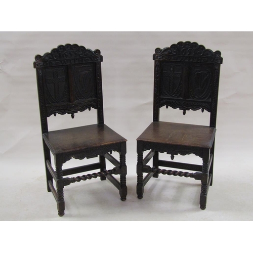 310 - A pair of 17c oak side chairs with solid seats, the back panels carved with two shields, one with a ... 