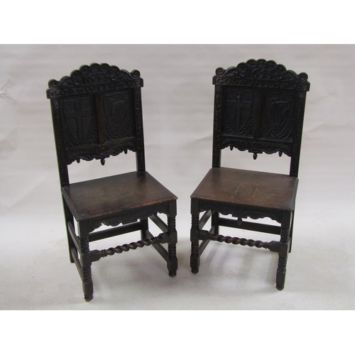 310 - A pair of 17c oak side chairs with solid seats, the back panels carved with two shields, one with a ... 