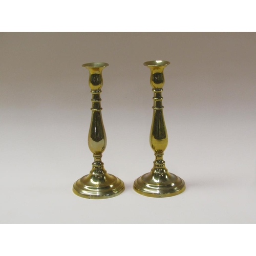 61 - A pair of William IV brass candlesticks with baluster stems and fixed soccles on circular stepped ba... 