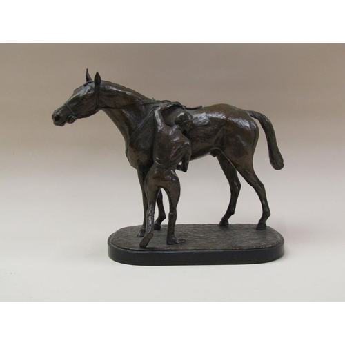 65 - A patinated bronze of a jockey about to mount a horse, the base inscribed J Walwyn 1961, and support... 