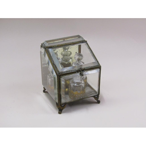 87 - A late Victorian glass scent bottle stand containing three glass bottles, with bevel edge glass wind... 