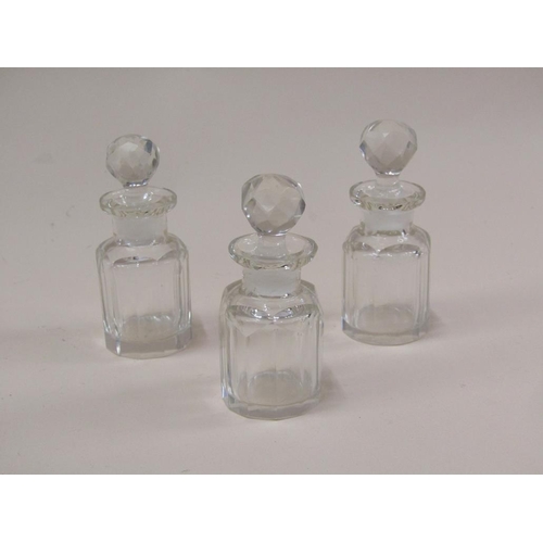 87 - A late Victorian glass scent bottle stand containing three glass bottles, with bevel edge glass wind... 