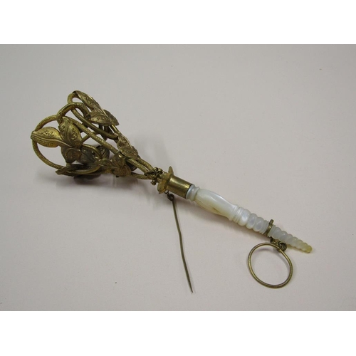 91 - A Victorian gilt metal posy holder with a turned and shaped mother of pearl handle, having attached ... 