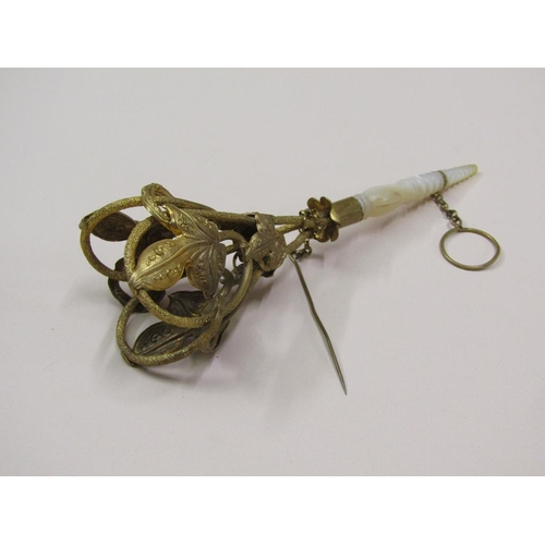 91 - A Victorian gilt metal posy holder with a turned and shaped mother of pearl handle, having attached ... 