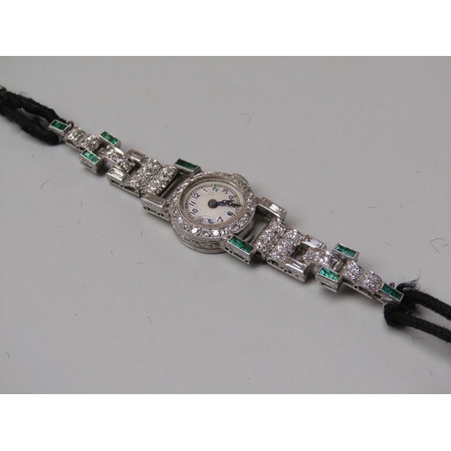 94 - An early 20c platinum, diamond and emerald set ladies wristwatch with a seventeen jewel movement.