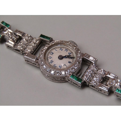 94 - An early 20c platinum, diamond and emerald set ladies wristwatch with a seventeen jewel movement.